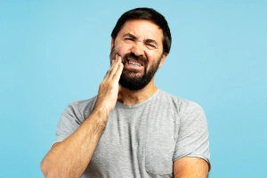 Man holding cheek in pain