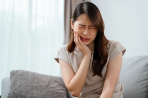 Man holding cheek in pain